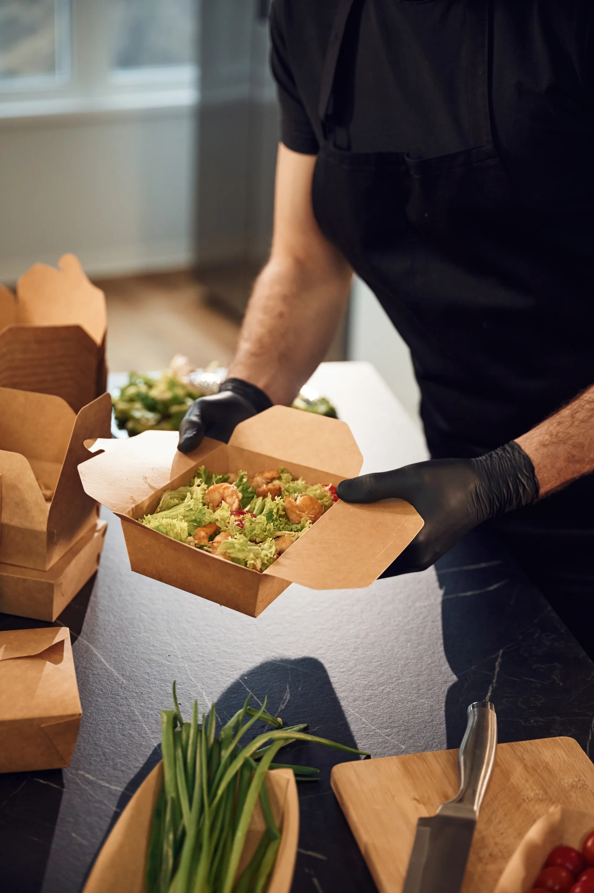 Mãos com luva embalando comida em bag de delivery