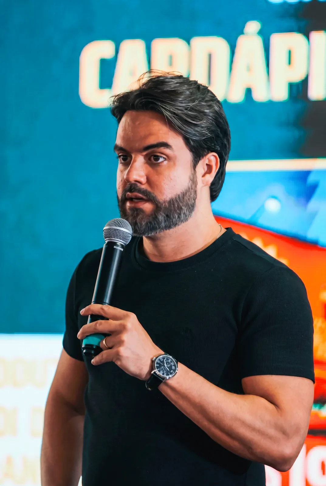 Lucas Profeta falando ao microfone num evento da Politi Academy