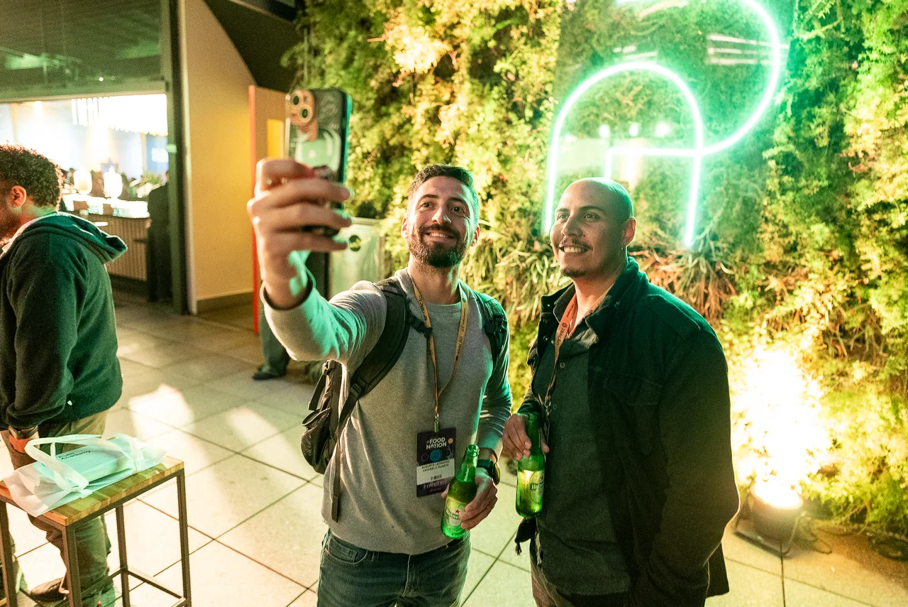 Pessoas tirando selfie em ambiente com luz neon