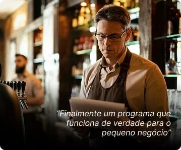 Homem de avental em um bar lendo um documento. Texto sobreposto: "Finalmente um programa que realmente funciona para pequenas empresas".