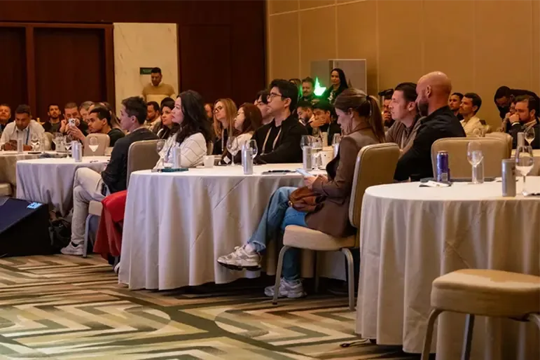 Mesas redondas em sala de conferência ouvindo palestrante